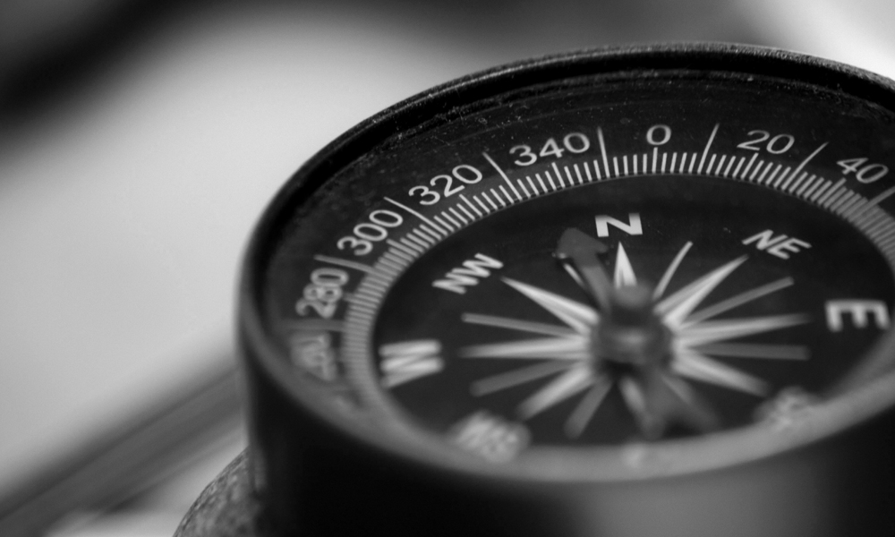 Black and white image of a compass with the needle pointing north