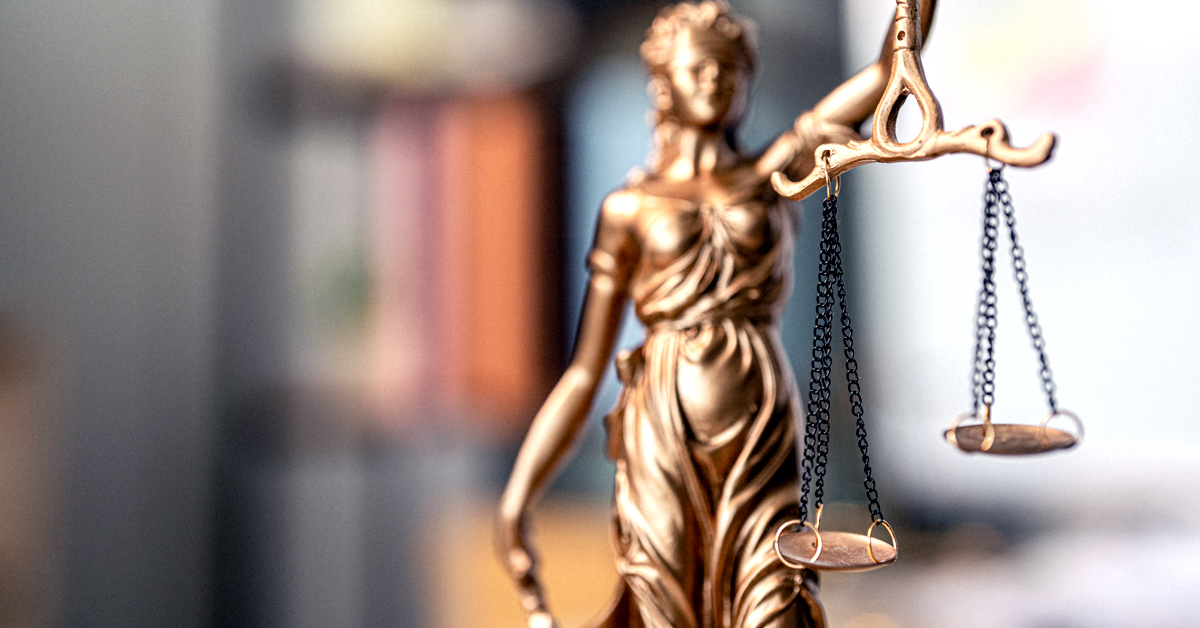 Scales of Justice statue in front of a blurred out background